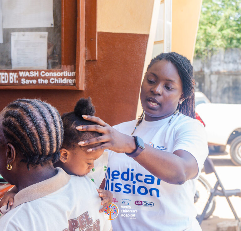 A health worker examining a young child outdoors